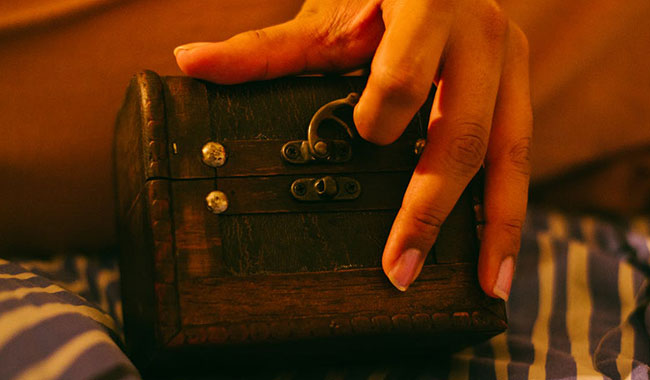 small box with latch being opened by womans hand