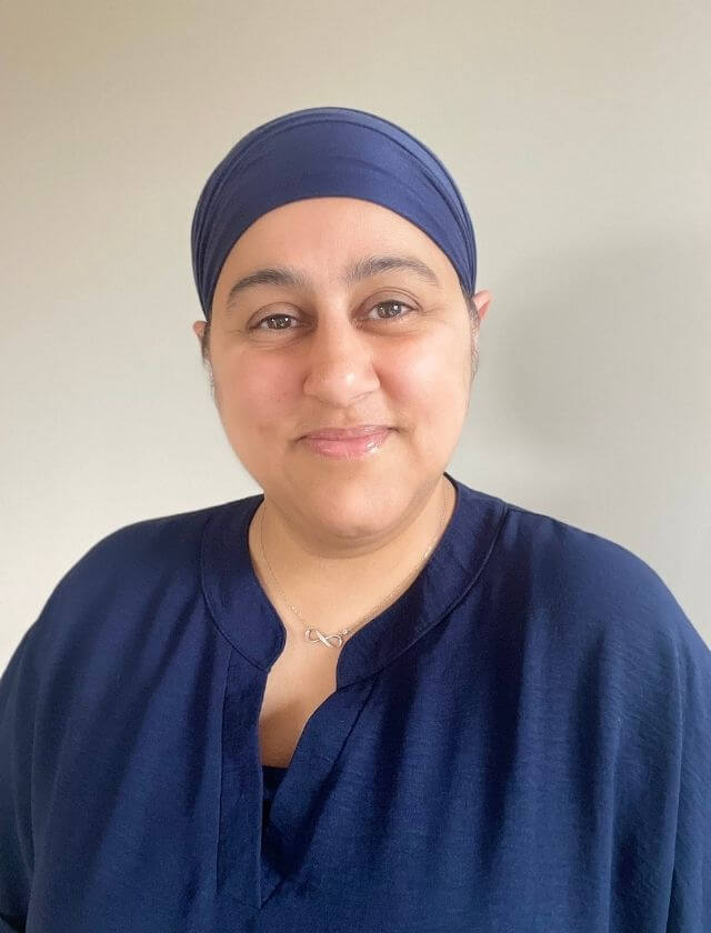 Image of Dr Kaur Clinical Psychologist smiling and wearing all navy